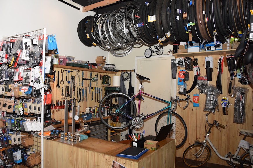 Vélo sur pied de réparation, outils et roues dans l’atelier